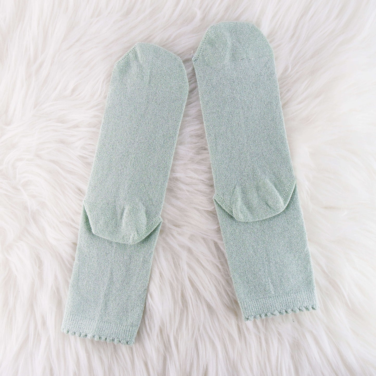 sage glitter socks, providing a stylish and shimmery accessory to enhance the overall look of any outfit.