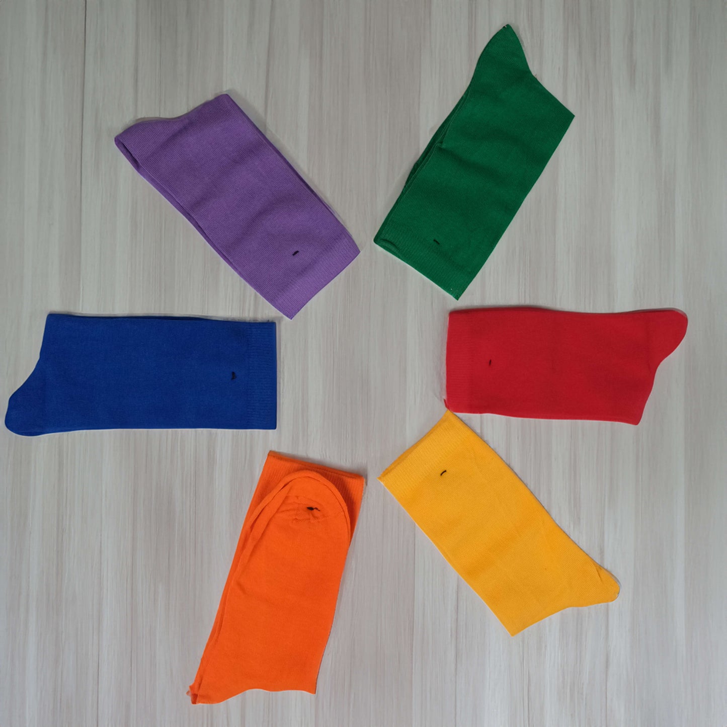 Six-pair pack of vibrant solid pattern cotton socks in assorted colors. Includes hues like navy blue, red, green, yellow, purple, and pink. A stylish and comfortable addition to your everyday wardrobe.