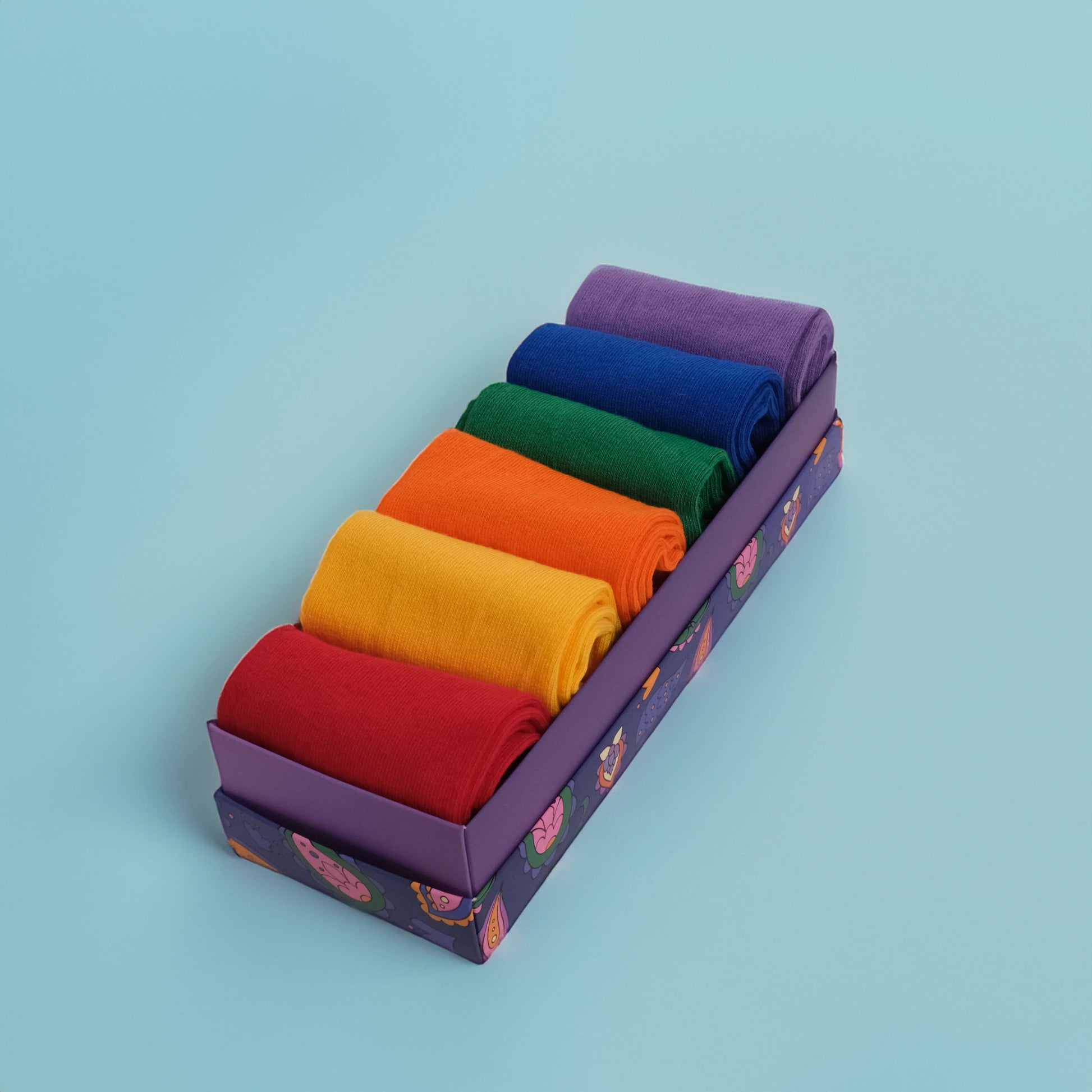 Assortment of six pairs of cotton socks featuring solid patterns in a spectrum of colors, including navy blue, red, green, yellow, purple, and pink.