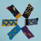 Quirky and fun patterned socks with images of bananas, hotdogs, beer mugs, cheese, hot sauce bottles, and avocados. A playful and stylish addition to your sock collection.