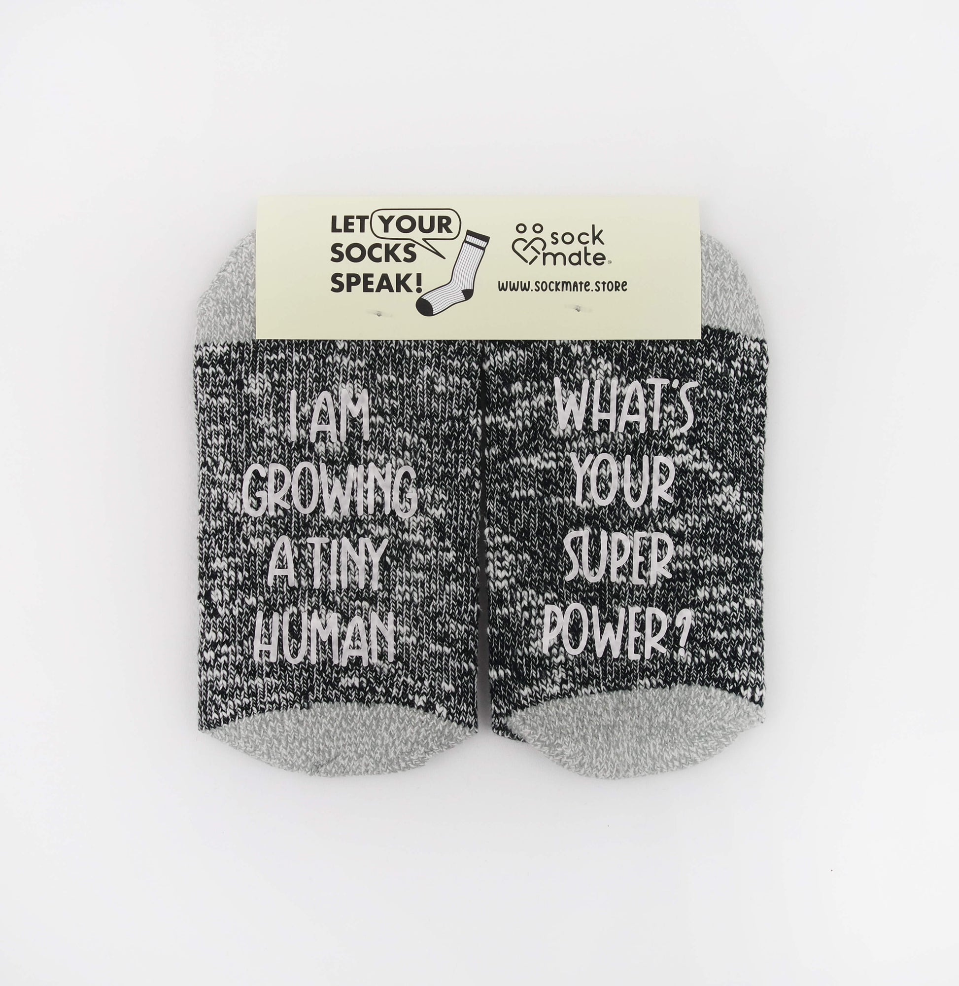 Socks with a lighthearted message for expectant mothers, reflecting the realities of pregnancy with the phrase 'I am growing a tiny human, What's your super power?