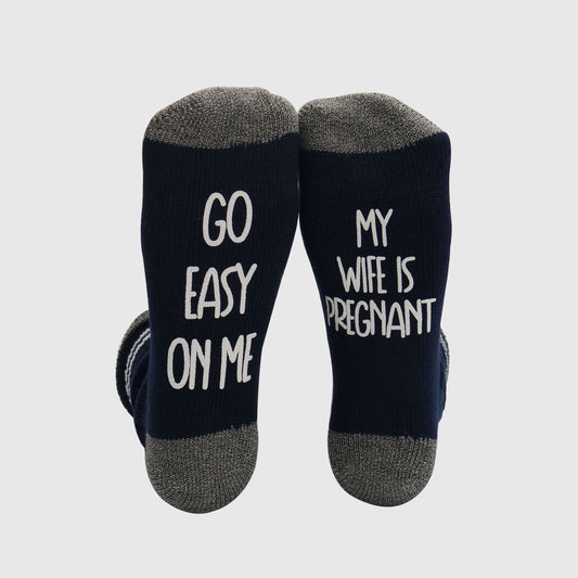Socks with a charming and informative phrase about pregnancy, reminding others to be considerate and supportive with the messages 'GO EASY ON ME' and 'MY WIFE IS PREGNANT.