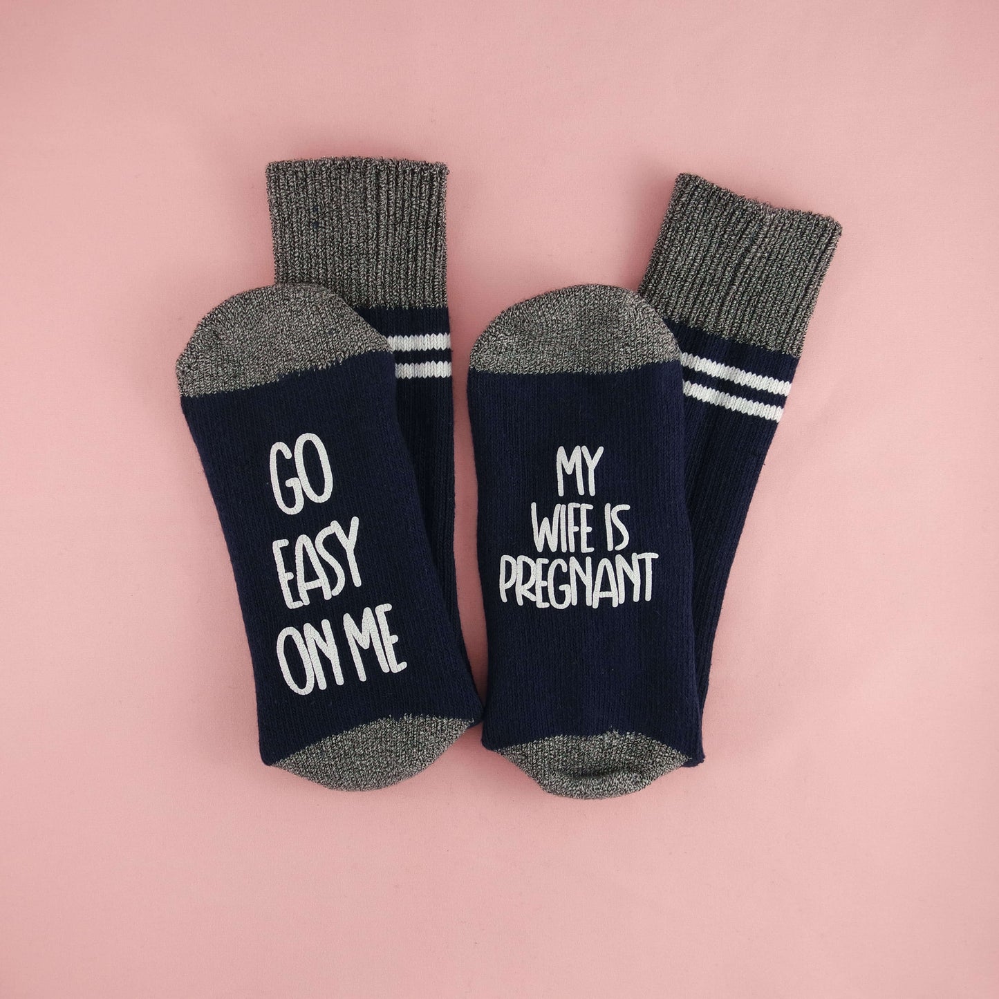 socks with a light-hearted message for expectant fathers, emphasizing the need for understanding and patience during pregnancy with the phrases 'GO EASY ON ME' and 'MY WIFE IS PREGNANT.