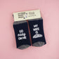 Socks featuring a playful and supportive pregnancy message, encouraging empathy and kindness for expectant fathers with the phrases 'GO EASY ON ME' and 'MY WIFE IS PREGNANT.
