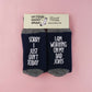 Socks adorned with a humorous statement, revealing the wearer's concentration on perfecting their dad jokes with the phrase 'Sorry I just can't today, I am working on my dad jokes.'