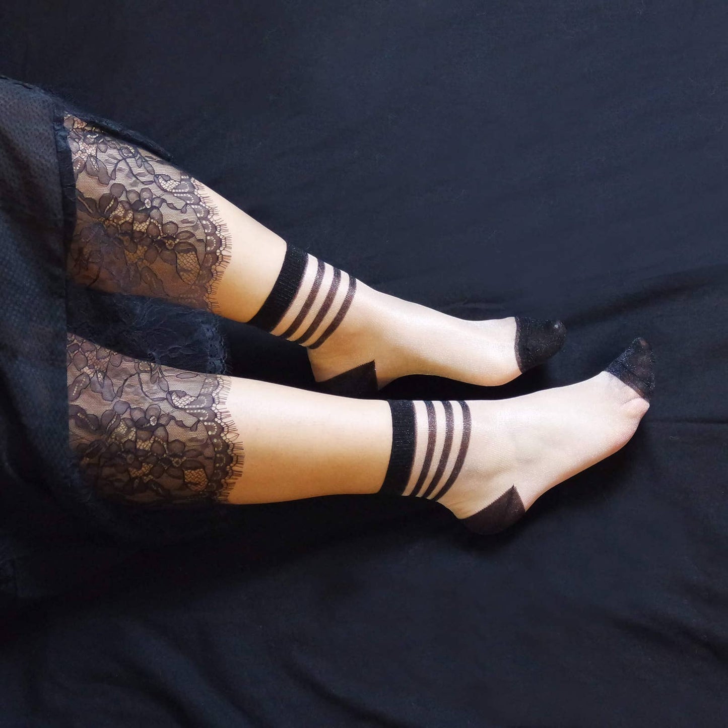 Sheer socks with black stripes, a chic and contemporary choice for women's fashion.