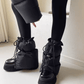 Gray quilted puff boot covers with drawstring ties, worn over sneakers and paired with black leggings.