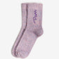 Two lilac fuzzy socks with purple “Pam” embroidery neatly stacked on white background, showing soft fluffy knit detail.