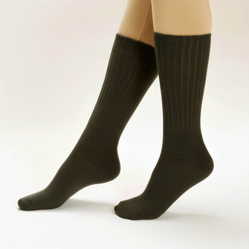 Dark green knee-high socks worn with beige tights on a white background