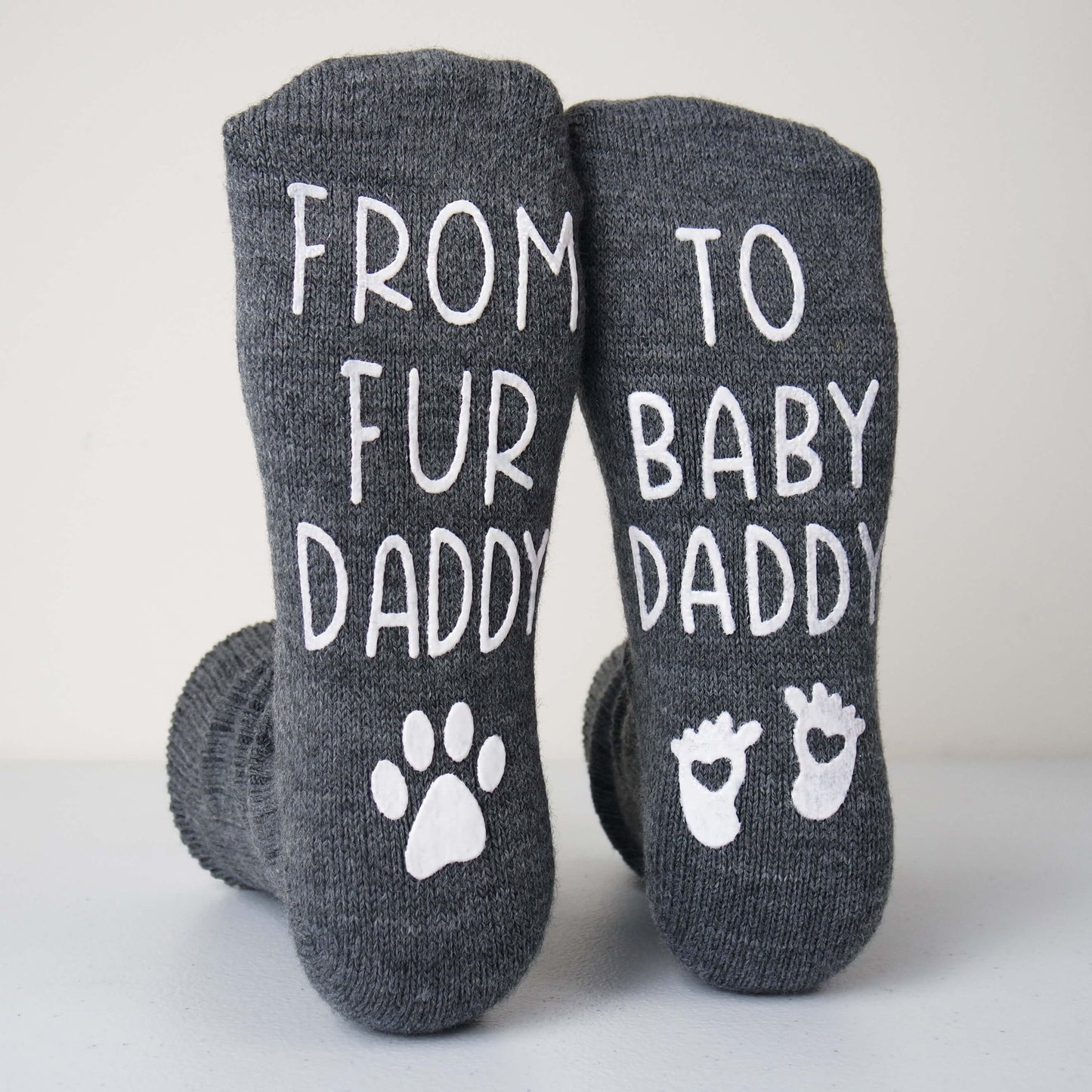 Gray socks with text and paw prints on a light background