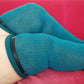 a woman wears teal color plus size thigh high socks and uses garter belt for keep her over knee socks